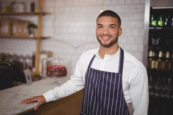 Handsome waiter standing by counter — Stock Photo, Image