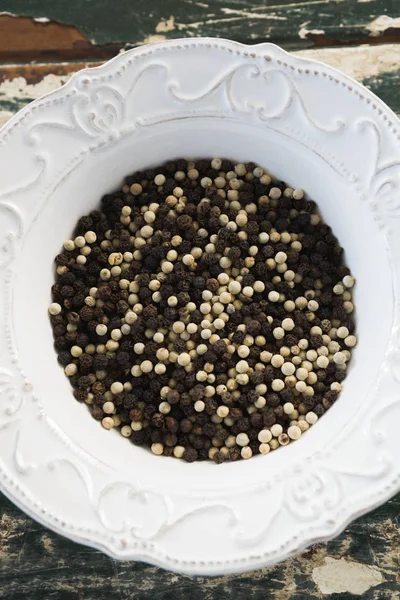 Mezclar granos de pimienta en el plato —  Fotos de Stock