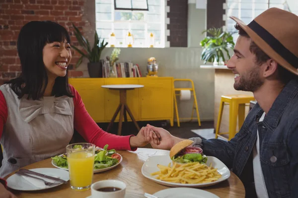 Couple holding hands at cafe — Stock Photo, Image