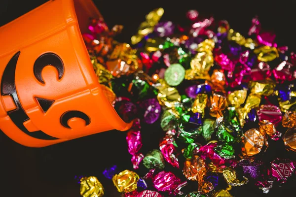 Vista de alto ângulo do balde com chocolates coloridos durante o Halloween — Fotografia de Stock