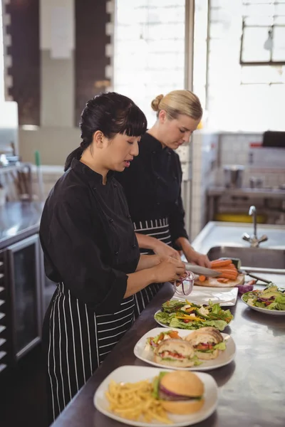 Vrouwelijke chef-koks bereiden van voedsel in keuken — Stockfoto