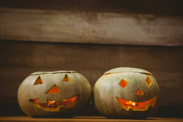 Oświetlony jack o latarnie na stole podczas Halloween — Zdjęcie stockowe