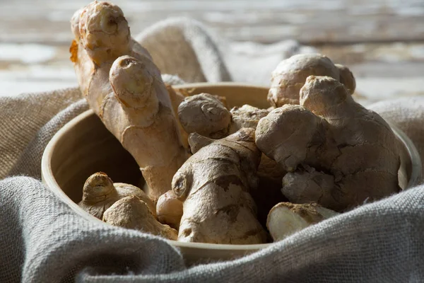 Färsk gingers i skål på säckväv — Stockfoto