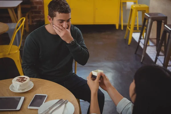 Mujer regalando anillo a novio en la cafetería — Foto de Stock