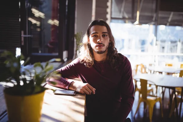 Mannen med långt hår som sitter på kafé — Stockfoto