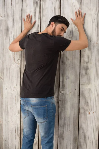 Man poseren tegen houten achtergrond — Stockfoto