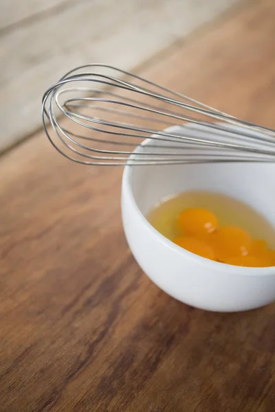 Яйцо в миске с проволочным венчиком — стоковое фото
