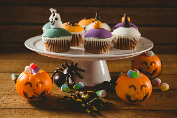 Bolos de xícara com decorações na mesa durante o Halloween — Fotografia de Stock