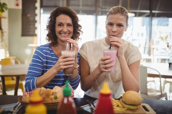 Female friends drinking milkshake — Stock Photo, Image