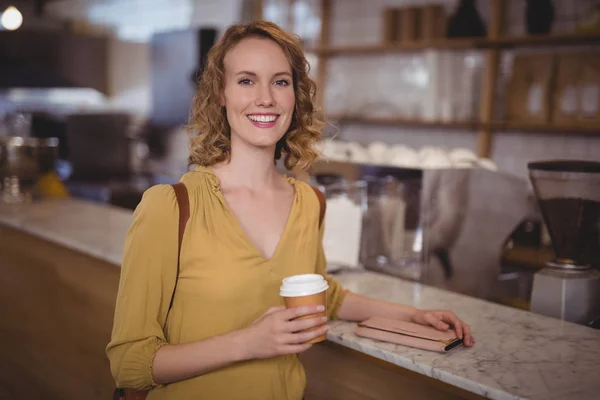 Female customer holding disposable coffee cup — Stock Photo, Image