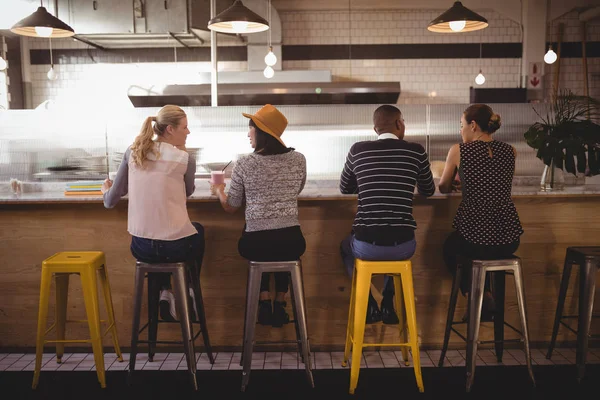 friends sitting on stool at counter