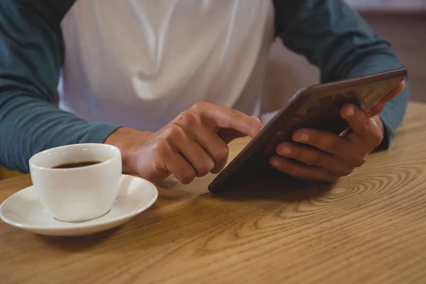 Hombre con café usando la tableta en la cafetería —  Fotos de Stock