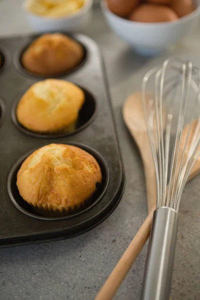 Muffins in tin by wire whisk — Stock Photo, Image