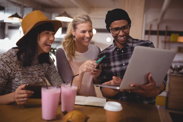 Man showing laptop to cheerful friends — Stock Photo, Image