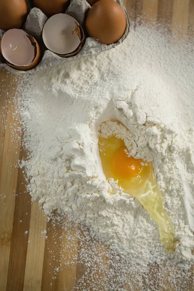 Egg yolk in flour ny carton on cutting board — Stock Photo, Image