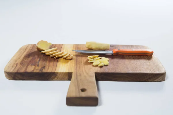 Chopped ginger and knife on cutting board — Stock Photo, Image