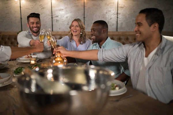 Freunde stoßen im Restaurant auf Champagner an — Stockfoto