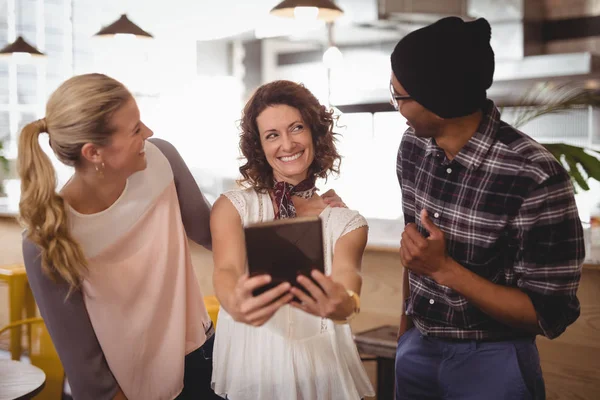 Amigos alegres de pé com tablet digital — Fotografia de Stock