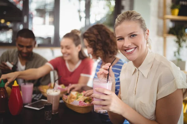 Woman holding milkshake at cafe — Stock Photo, Image