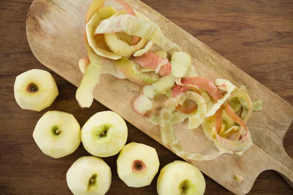 Fresh apples by peels on cutting board — Stock Photo, Image