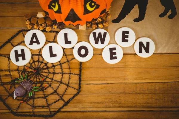 Biscoitos com texto de Halloween e decorações na mesa — Fotografia de Stock