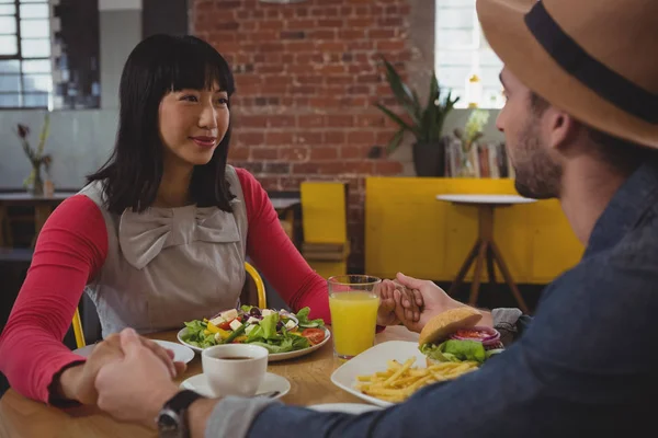 Echtpaar met voedsel hand in hand bij café — Stockfoto