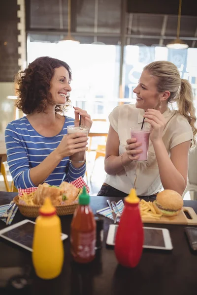 Female friends talking at cafe — Stock Photo, Image