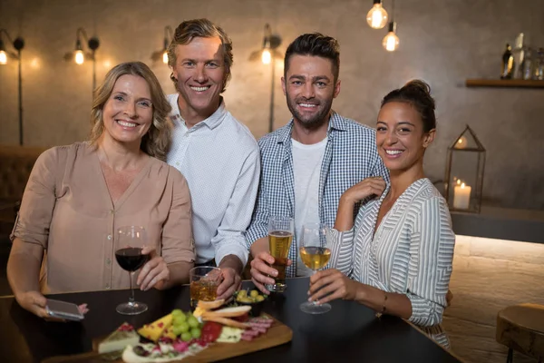 Glückliche Freunde bei Getränken und Essen — Stockfoto