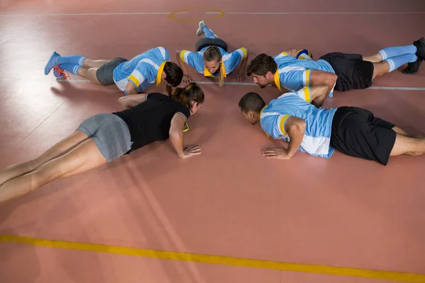 Команда волейболу робить віджимання з тренером — стокове фото