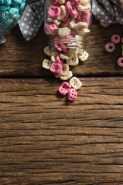 Cereales dispersos de tarro sobre mesa de madera — Foto de Stock