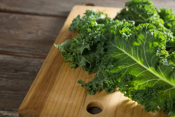 Kale leaves on wooden cutting board — Stock Photo, Image