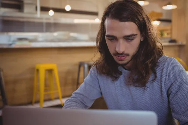 Young man using laptop in cafe — Stock Photo, Image