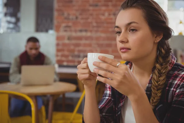 Thoughtful woman holding coffee cup — Stock Photo, Image
