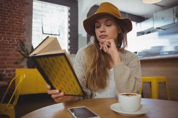 Kafede kitap okuyan bir kadın. — Stok fotoğraf