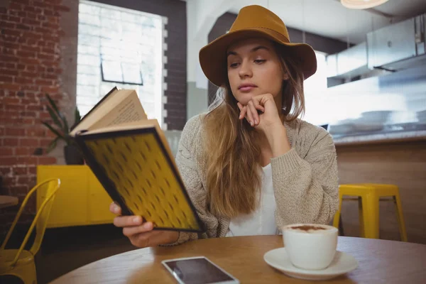 Frau liest Buch im Café — Stockfoto