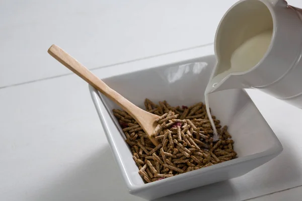 Verter leche en un tazón de palitos de salvado de cereales —  Fotos de Stock