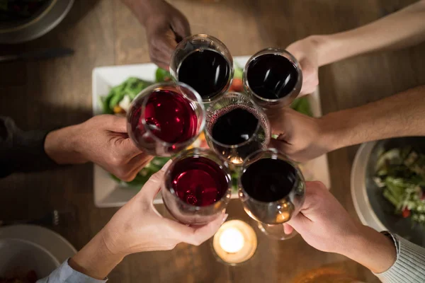 Vänner rosta rött vin i restaurang — Stockfoto