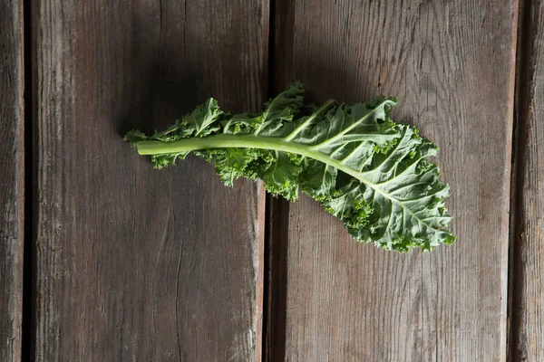 Fresh kale leaf on wooden table — Stock Photo, Image