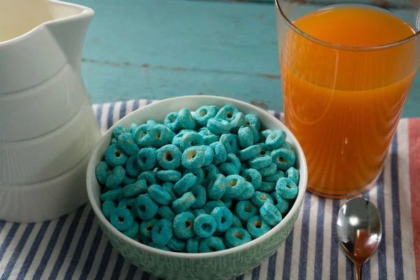 Cereal rings and orange juice on napkin cloth — Stock Photo, Image