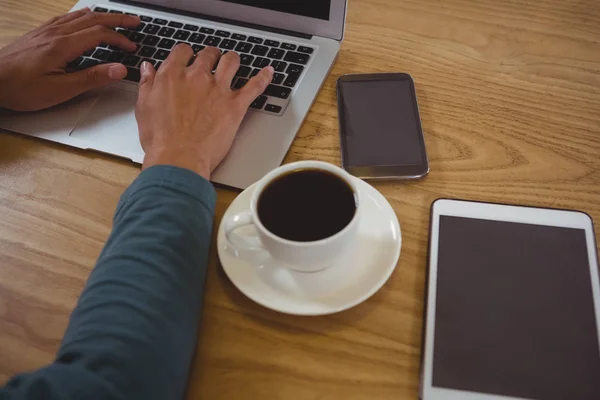 Uomo con caffè utilizzando il computer portatile in caffè — Foto Stock
