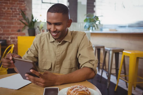 Człowiek za pomocą tabletu cyfrowego w kawiarni — Zdjęcie stockowe