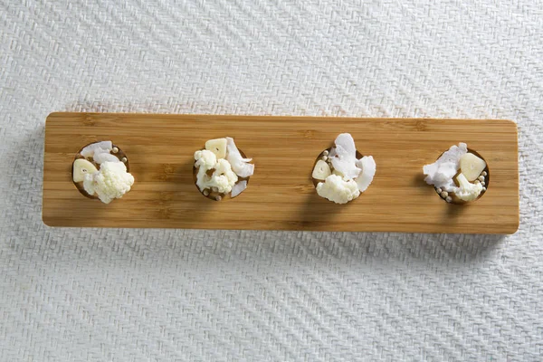 Cauliflowers with cheese on cutting board — Stock Photo, Image