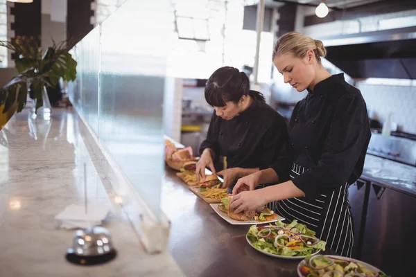 Köchinnen bereiten in Cafeteria frisches Essen zu — Stockfoto