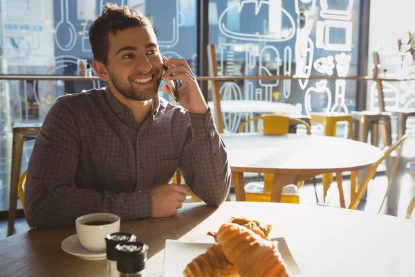 Mannen med frukost pratar telefon i café — Stockfoto