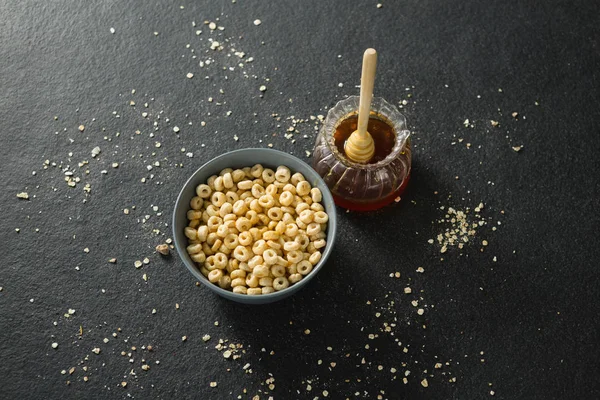 Dissipatore di miele e ciotola di anelli di cereali — Foto Stock
