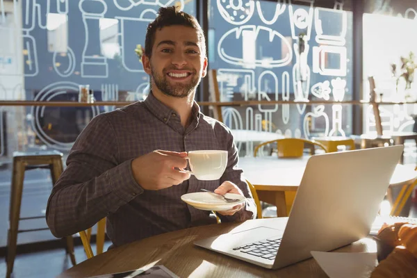 Бизнесмен пьет кофе в кафе — стоковое фото