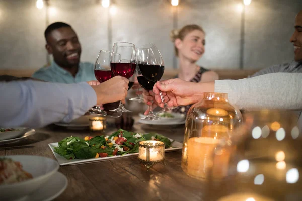 Freunde stoßen im Restaurant auf Rotwein an — Stockfoto