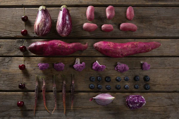Различные овощи расположены на деревянном столе — стоковое фото