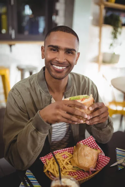 Uomo mangiare panino fresco alla caffetteria — Foto Stock