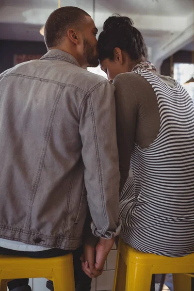 Mannen som kysser på kvinna huvud i café — Stockfoto